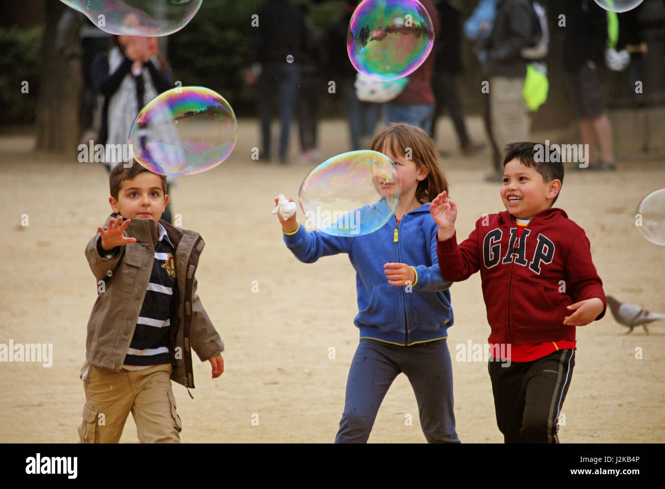 BARCELONA/SPAIN - 19 APRIL 2017: Childrean playing with big soap bubbles in Barcelona's Ciutadella park Stock Photo