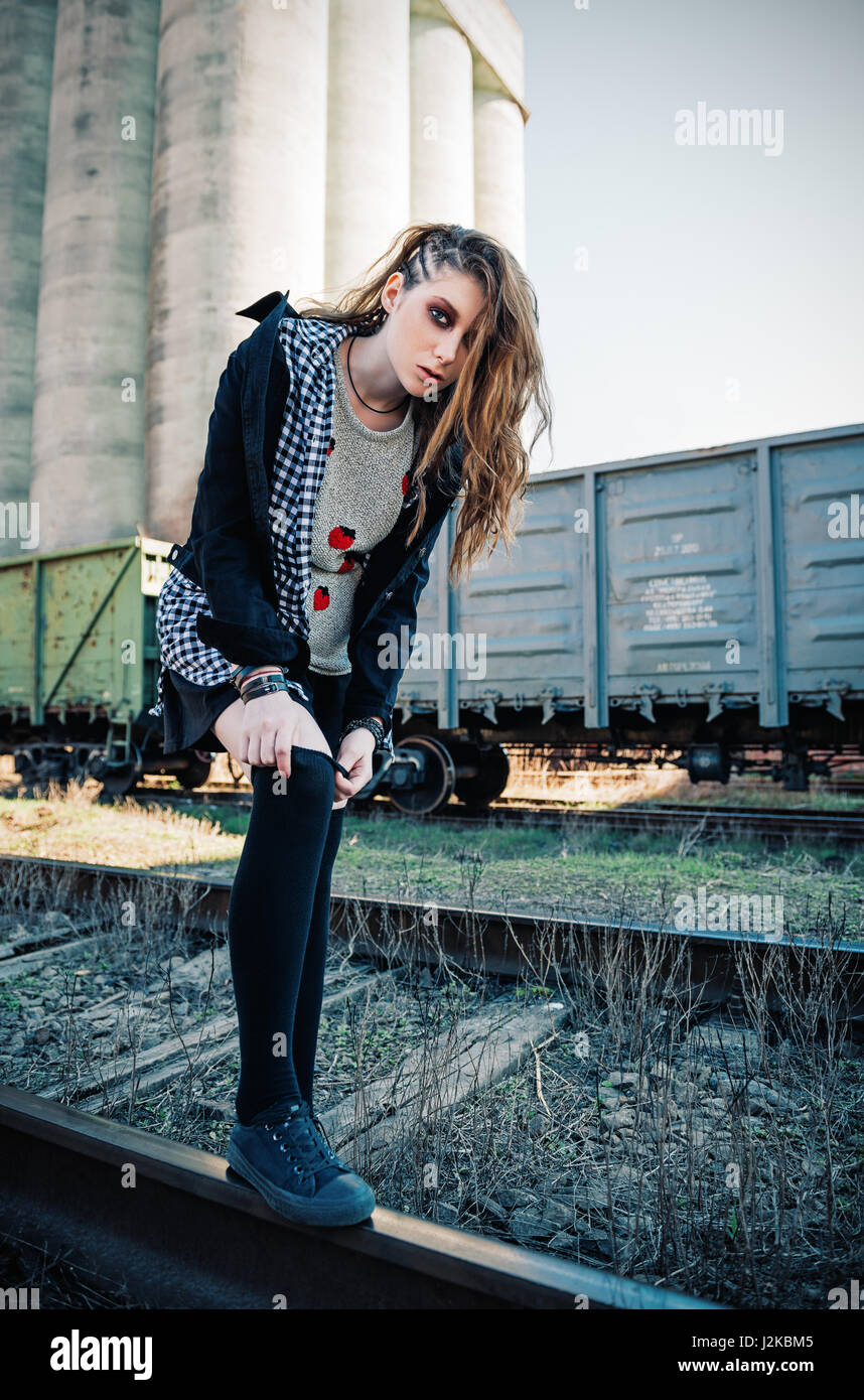 Outdoor portrait of the beautiful grunge (rock) girl at the rails Stock Photo