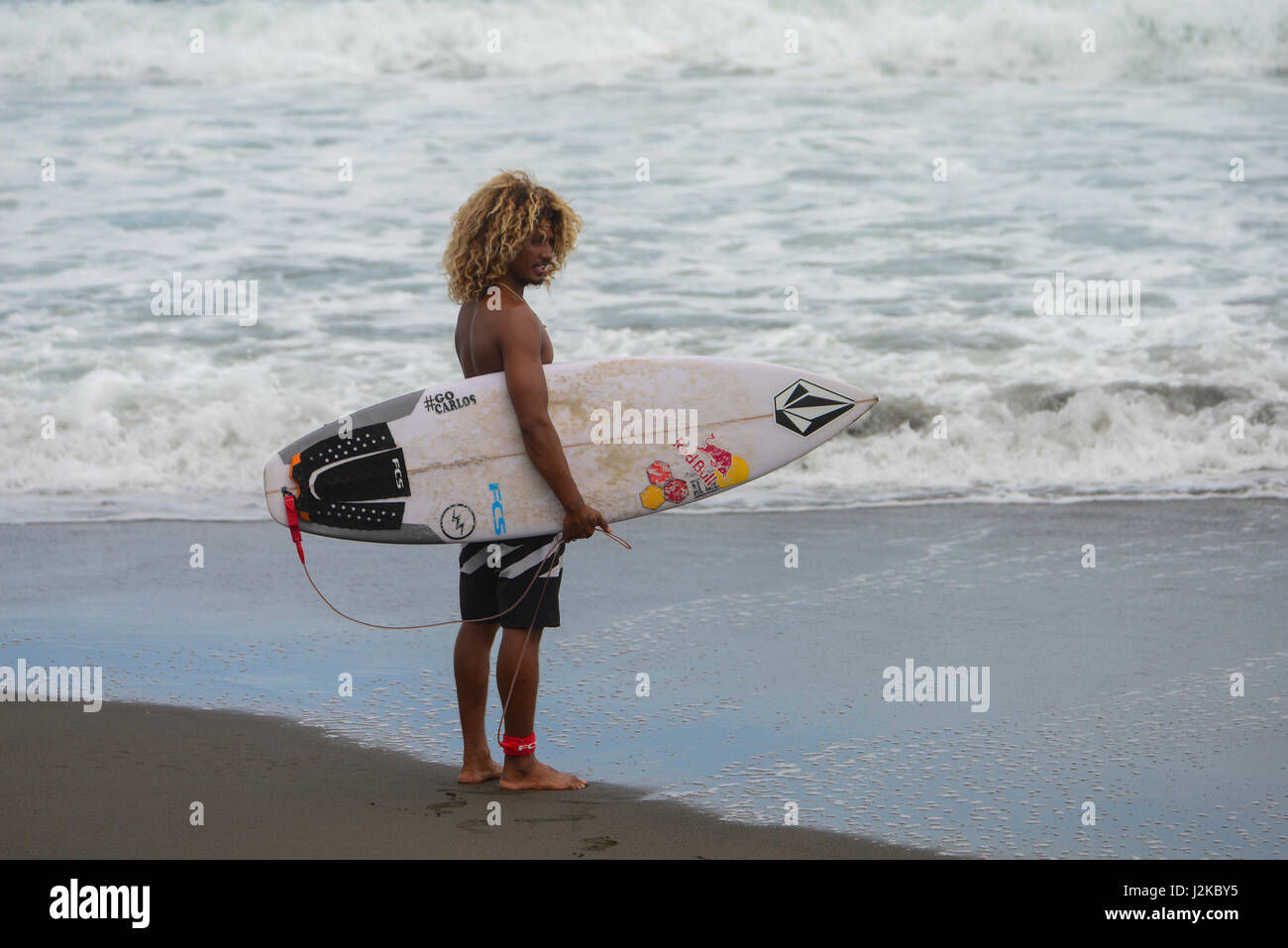 Carlos, 'Cali', Muñoz stands at the coastline in Playa Hermosa, Costa Rica. Stock Photo