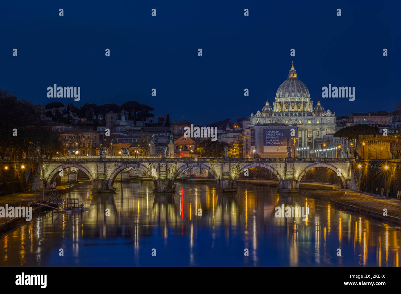 Basilica di San Pietro and the Vatican in Rome, Italy, viewed from the Ponte Sant'Angelo across the River Tiber and Ponte Vittorio Emanuele II at dawn Stock Photo