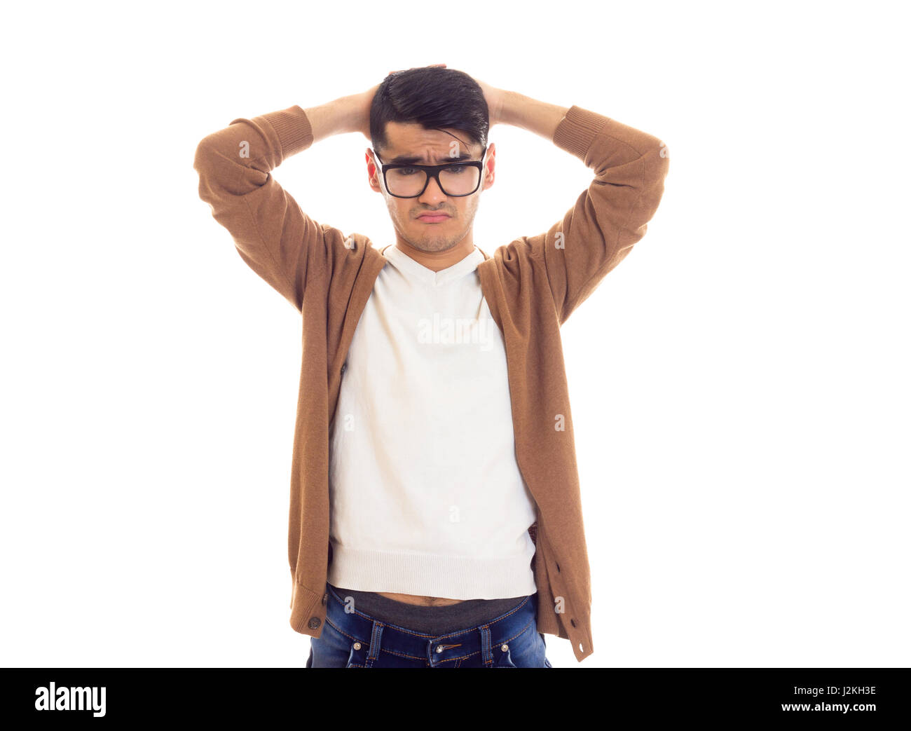 Young nice man with black hair in white T-shirt, brown cardigan and blue  jeans with black glasses on white background in studio Stock Photo - Alamy