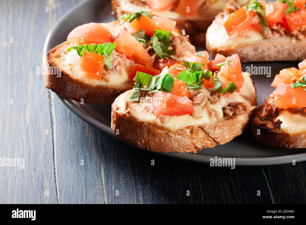 Appetizer bruschetta with tuna, mozarella cheese and tomatoes. Italian cuisine Stock Photo