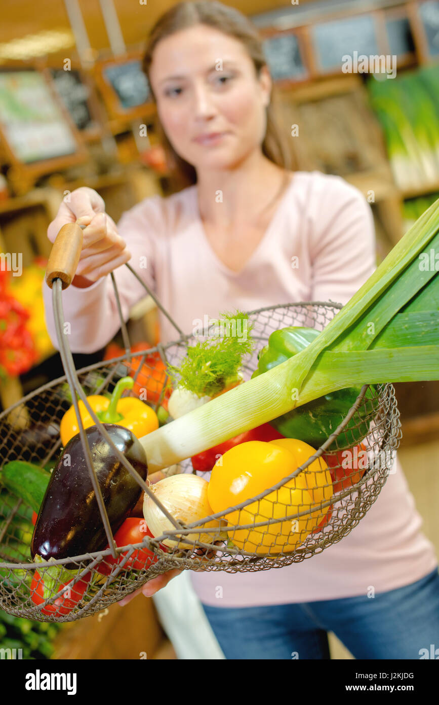 Lady holding forward a wire basket of fruit and vegetables Stock Photo ...