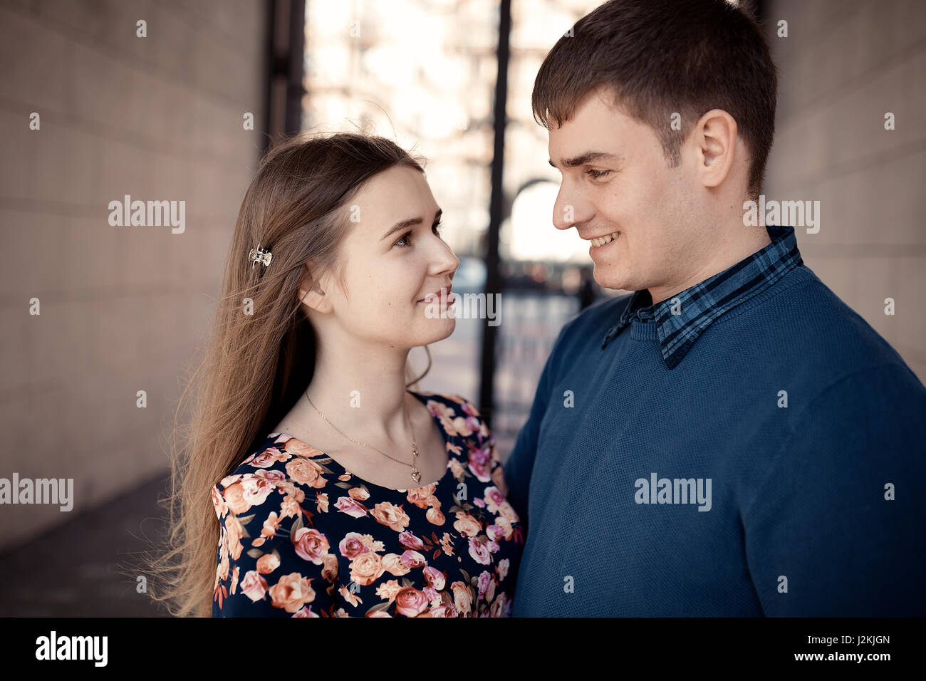 Pair in love in the city walking, laughing and have fun. Colorful warm yellow toning. Stock Photo