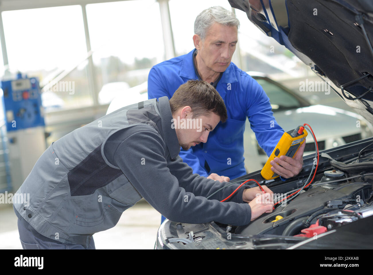 auto mechanic teacher and trainee performing tests at mechanic school