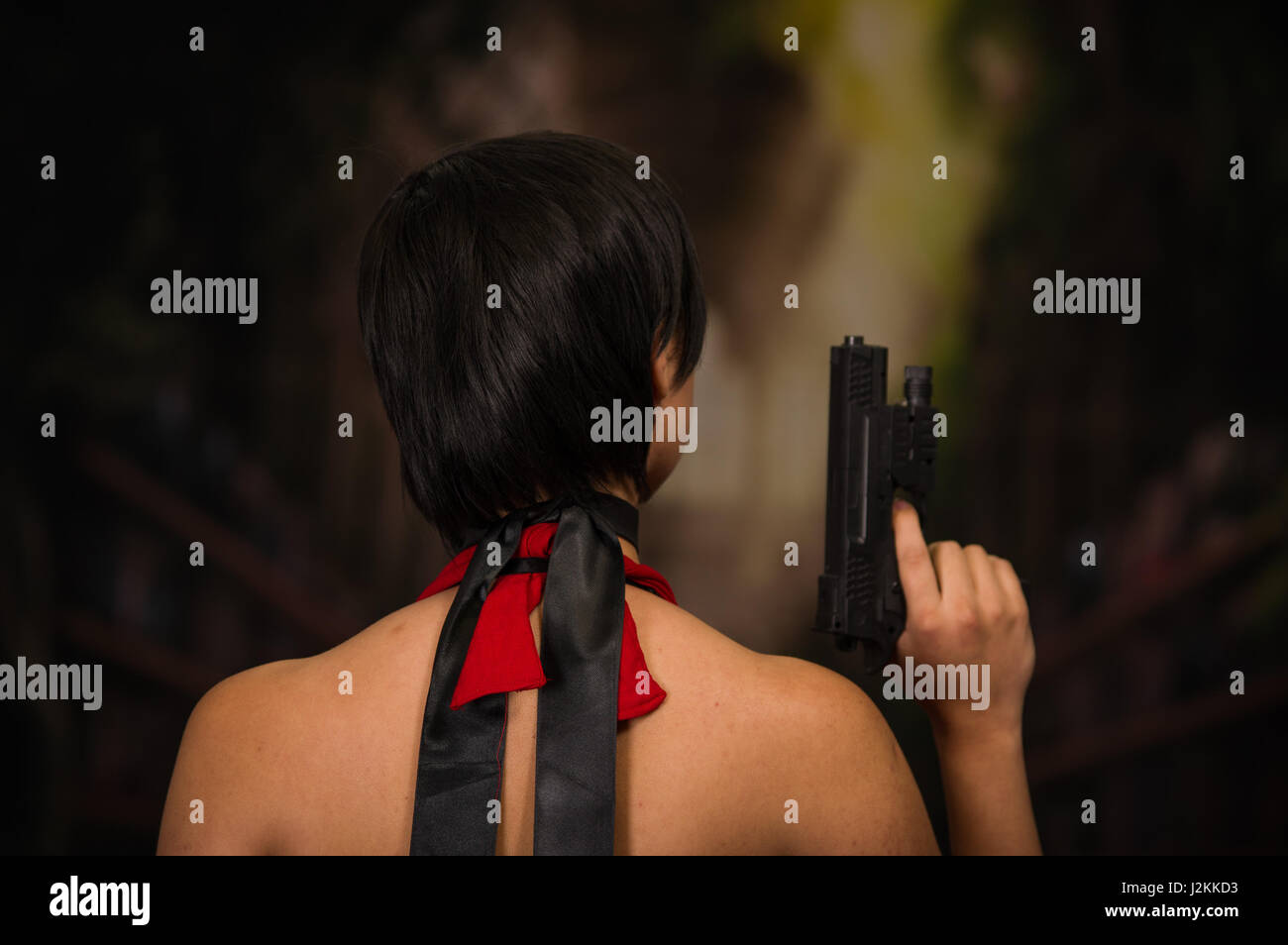 Powerful Woman Holding Gun, resident evil cosplay costume, back side Stock Photo