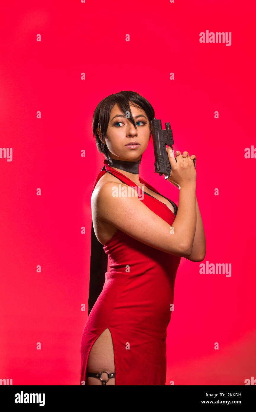 Powerful Woman posing with a gun in her face, ada wong cosplay Stock Photo