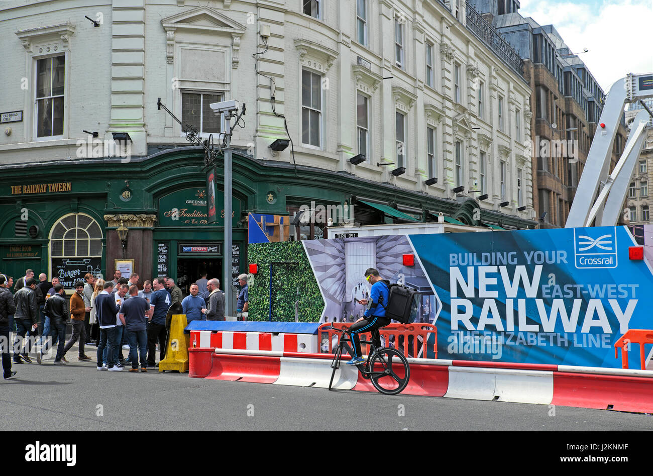 View of people pub & Crossrail construction hoarding for the new Elizabeth Line near Liverpool Street Station in the City of London UK   KATHY DEWITT Stock Photo