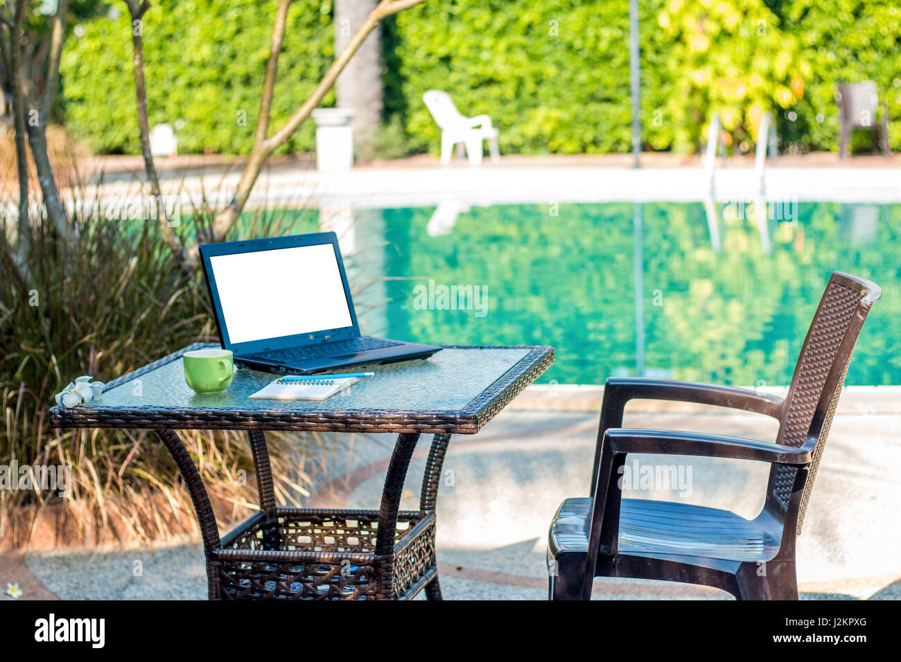 A Poolside Work Desk With A Table Top Coffee Mug And Notebook Is