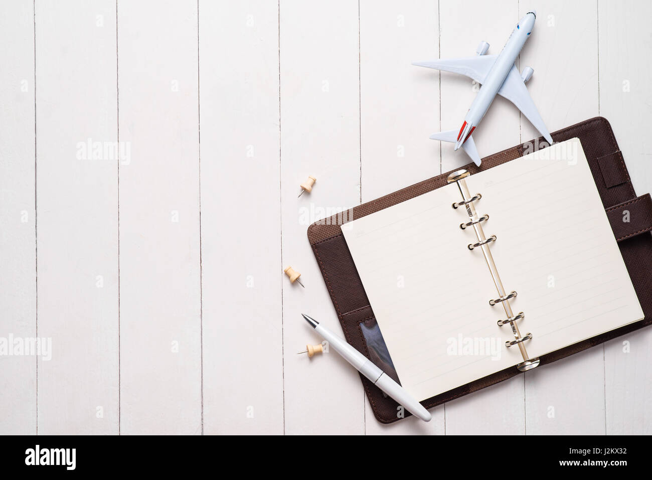 Business trip concept. Airplane and blank open notebook for your text. Stock Photo