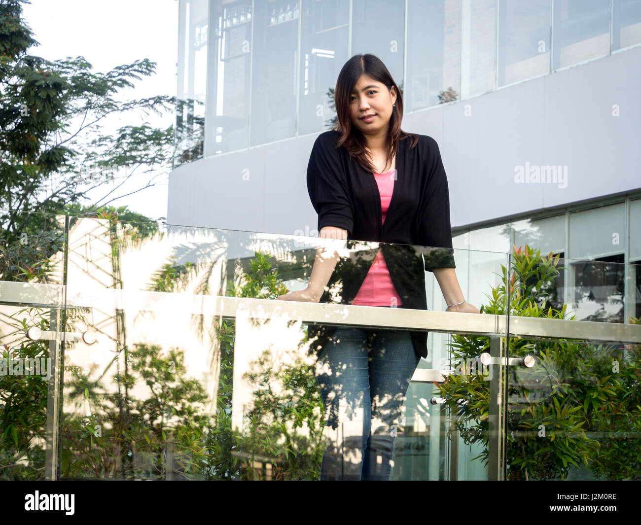 Beautiful Young Asian - Chinese Woman Smiling on Terrace Stock Photo