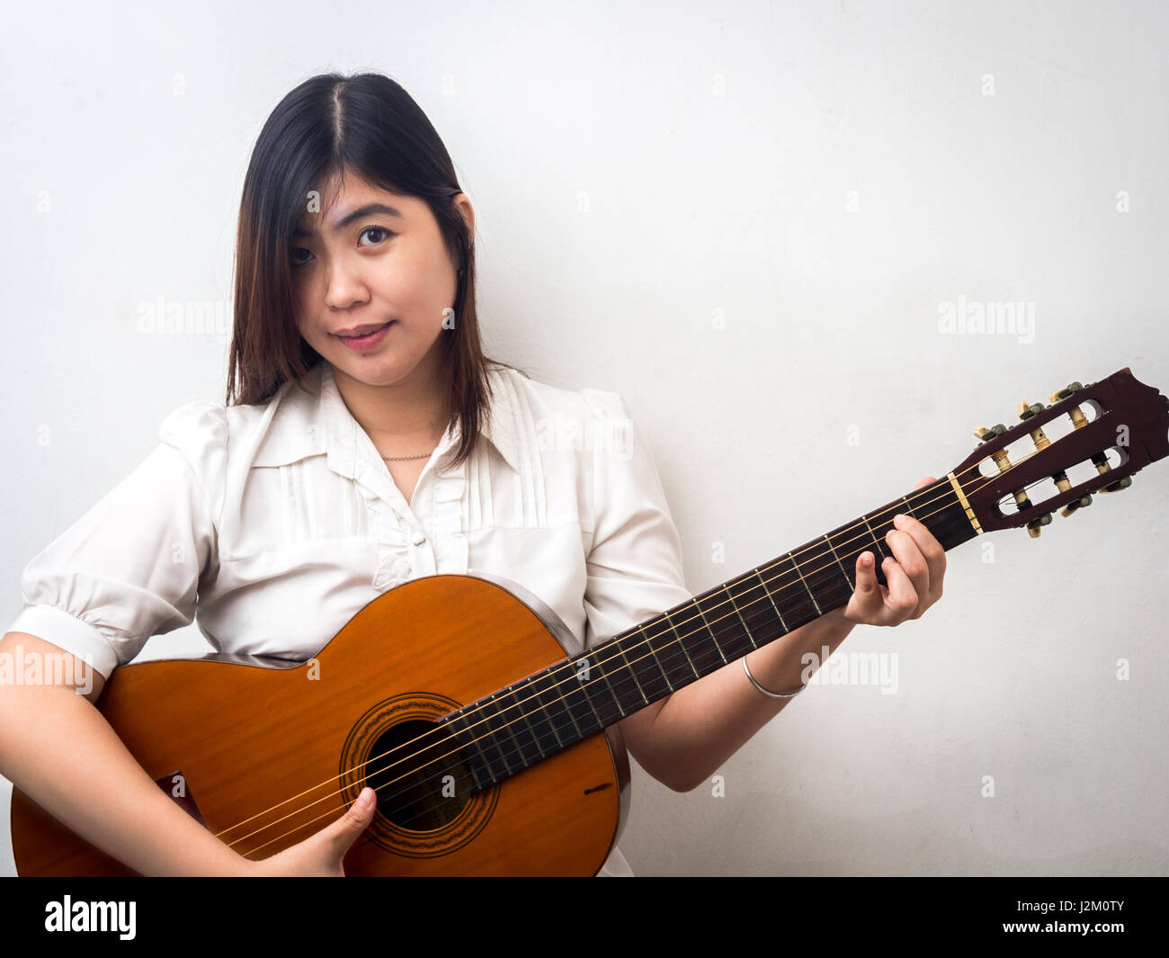 Beautiful Young Asian - Chinese Woman Playing Guitar Stock Photo