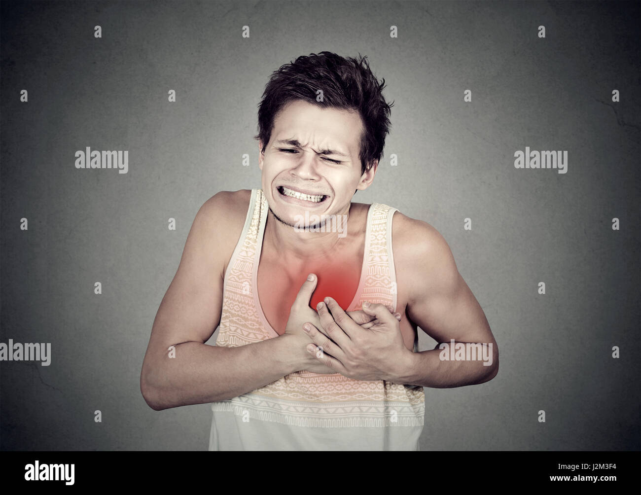 Adult man suffering from severe sharp heartache, chest pain. Heart