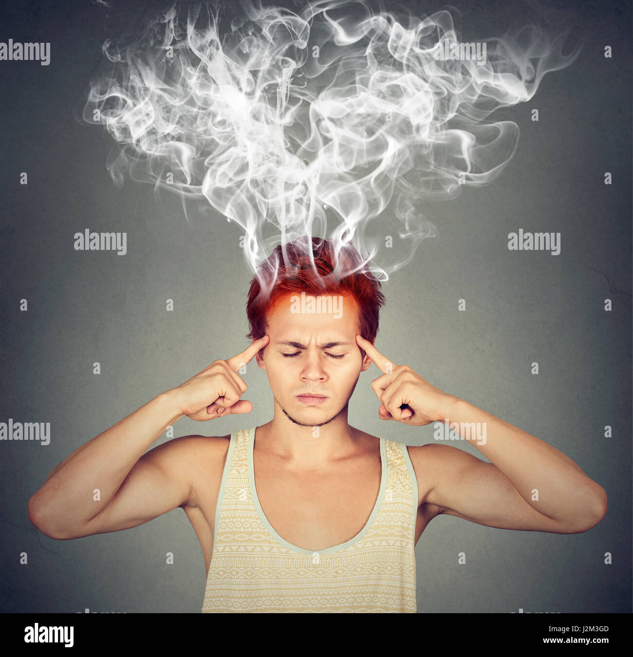 man thinks very intensely having headache isolated on gray wall background Stock Photo
