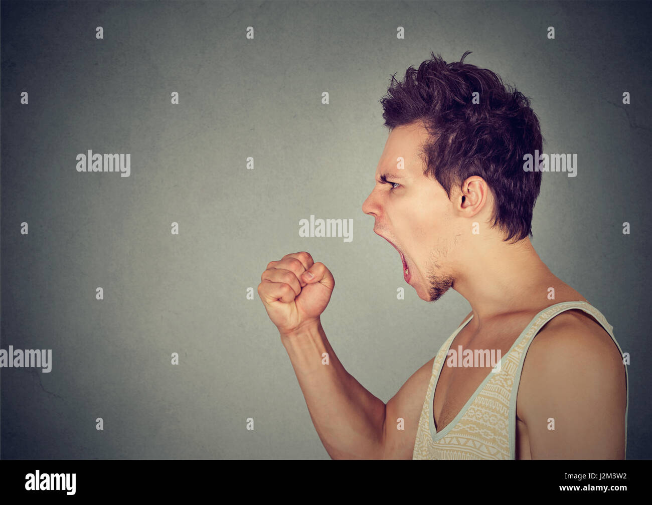 Side profile portrait of young angry man screaming Stock Photo