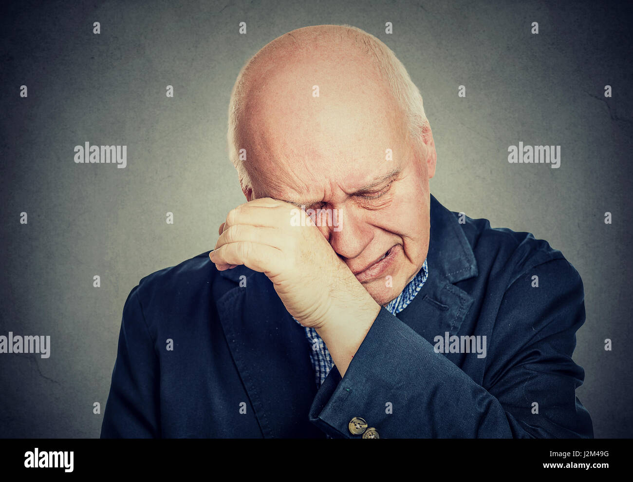 Sad senior man lonely grandfather, depressed crying isolated on gray background Stock Photo