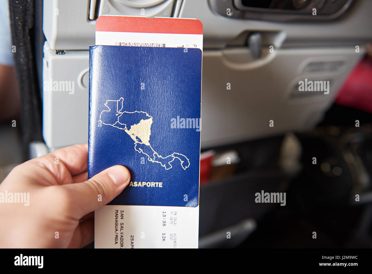 Close-up of passport with plane ticket on plane chair background Stock Photo
