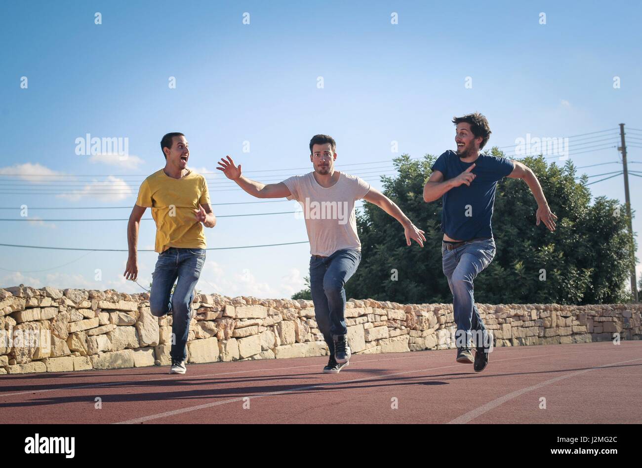 3 men running outside Stock Photo
