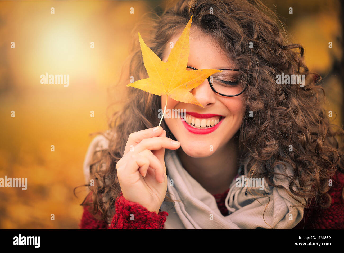 Pretty woman holding an autumn leaf Stock Photo