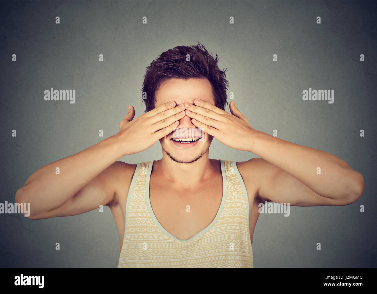 Portrait smiling man covering eyes his hands hires stock photography