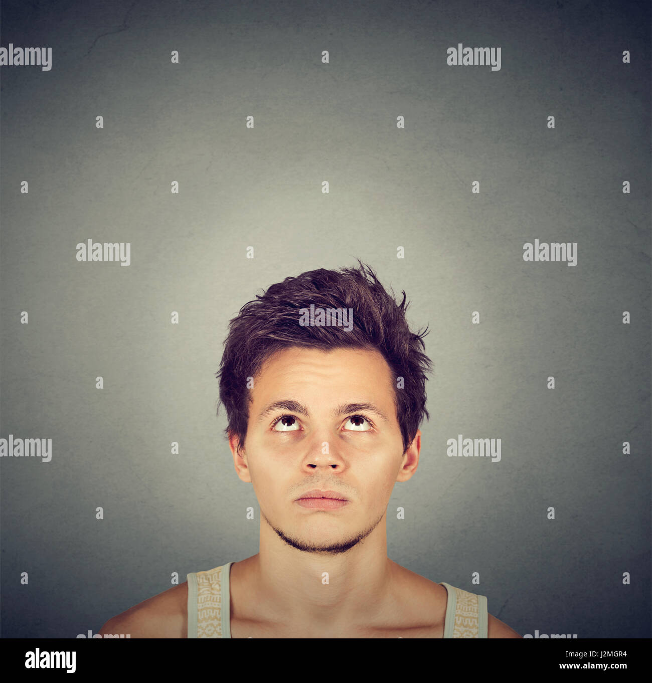 Headshot confused man thinking looking up isolated on gray background