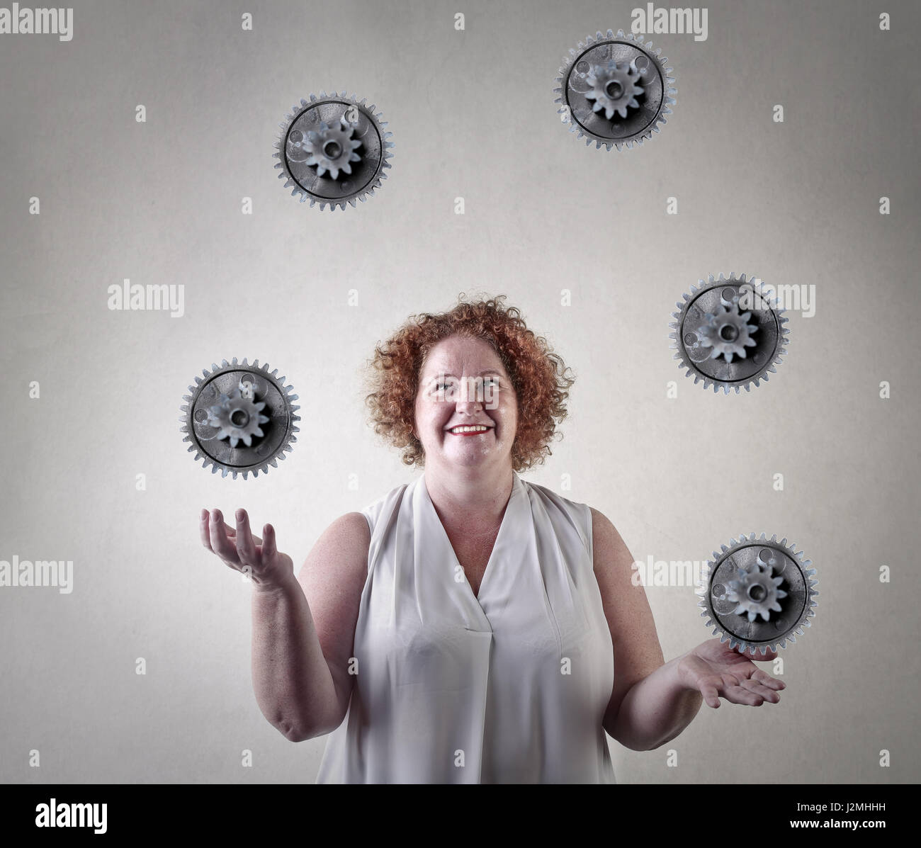 Woman juggling with gears Stock Photo