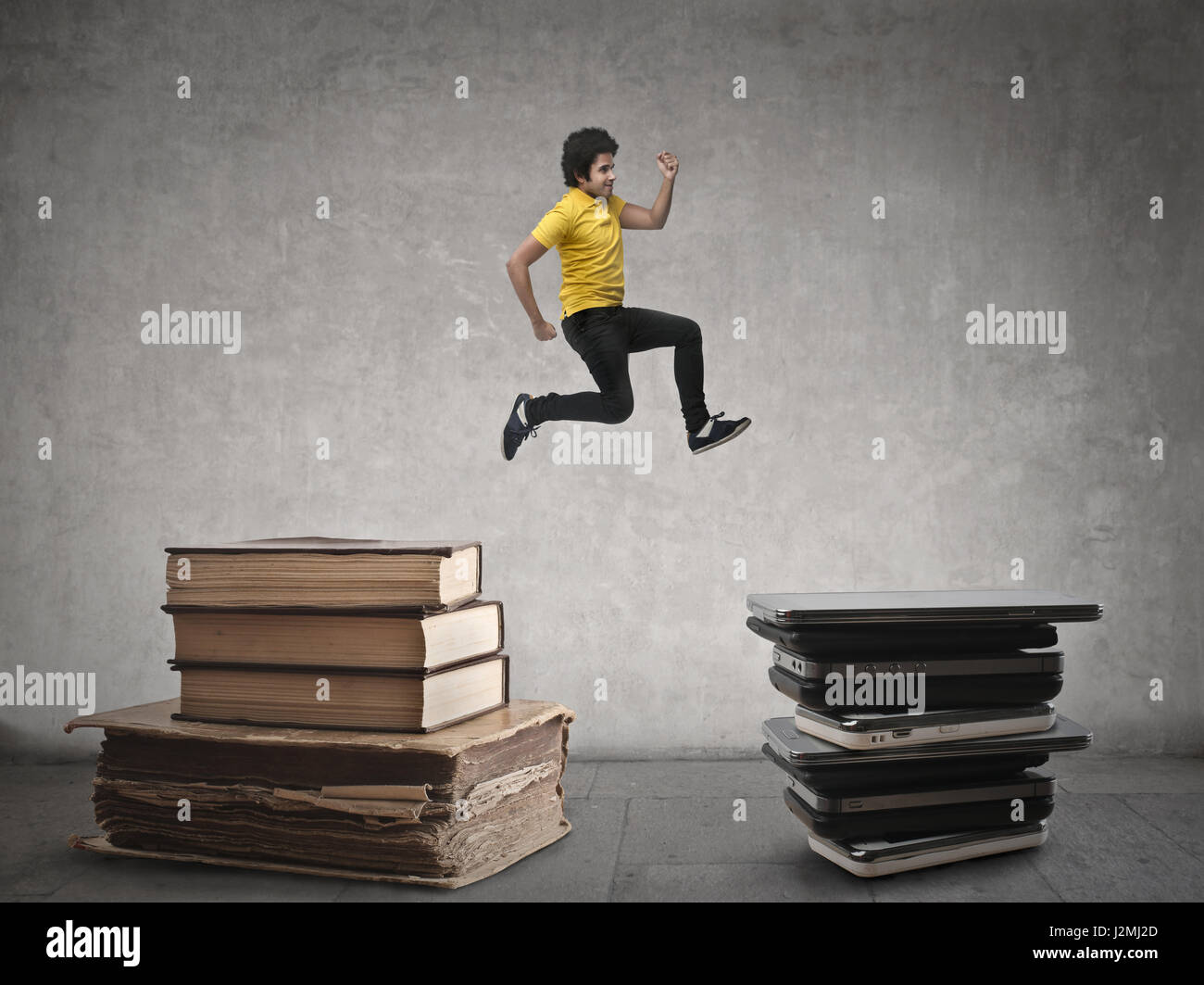 Man jumping from books to CDs Stock Photo