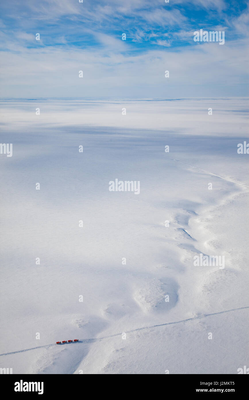 Trucks moving through out road in the snow covered tundra in vicinity of oil field, top view. Stock Photo