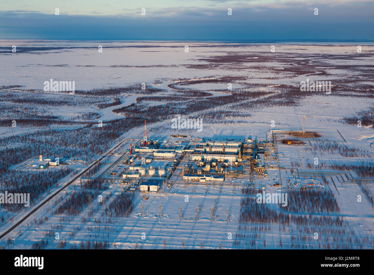 Oil and gas industry. Oil pump jack station in a oil field in tundra. Petrochemical object in West Siberia. Stock Photo