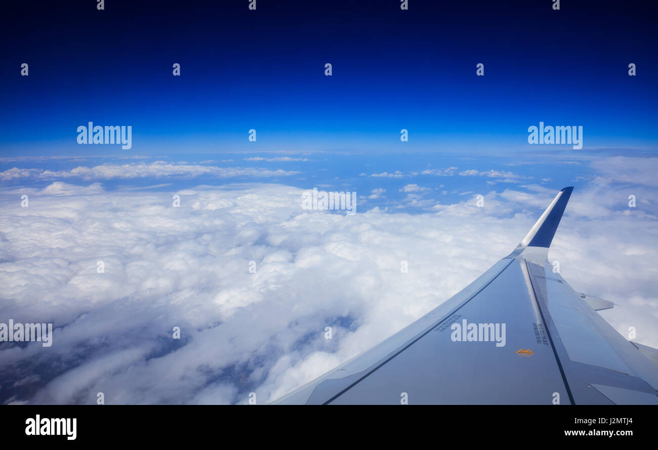 Wing of an airplane over clouds on a blue sky background Stock Photo ...