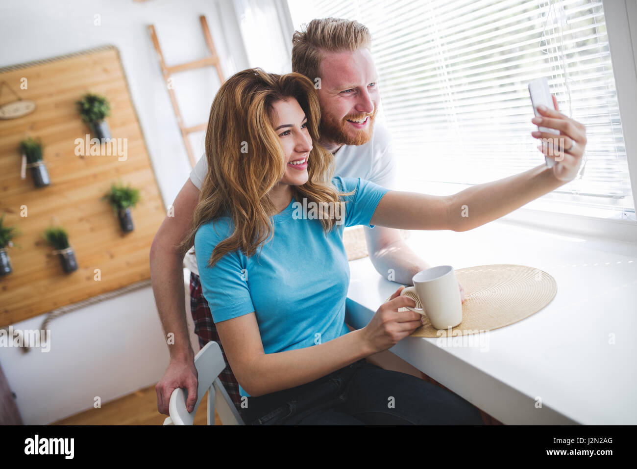 Romantic couple in love taking selfies and smiling at hime Stock Photo