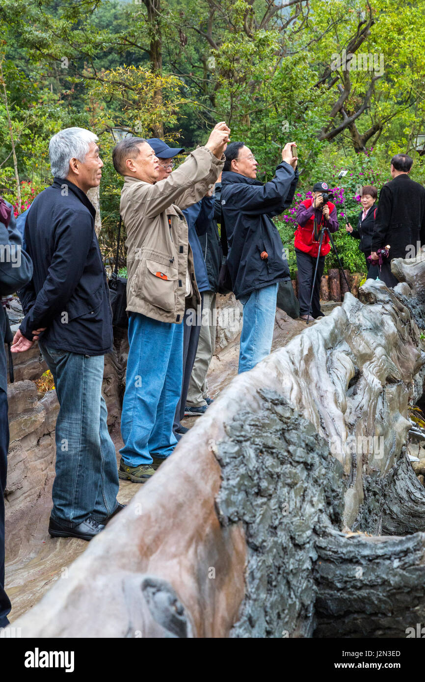 Zhaoxing, Guizhou, China.  Chinese Tourists Taking Pictures of the Entrance to the Village. Stock Photo