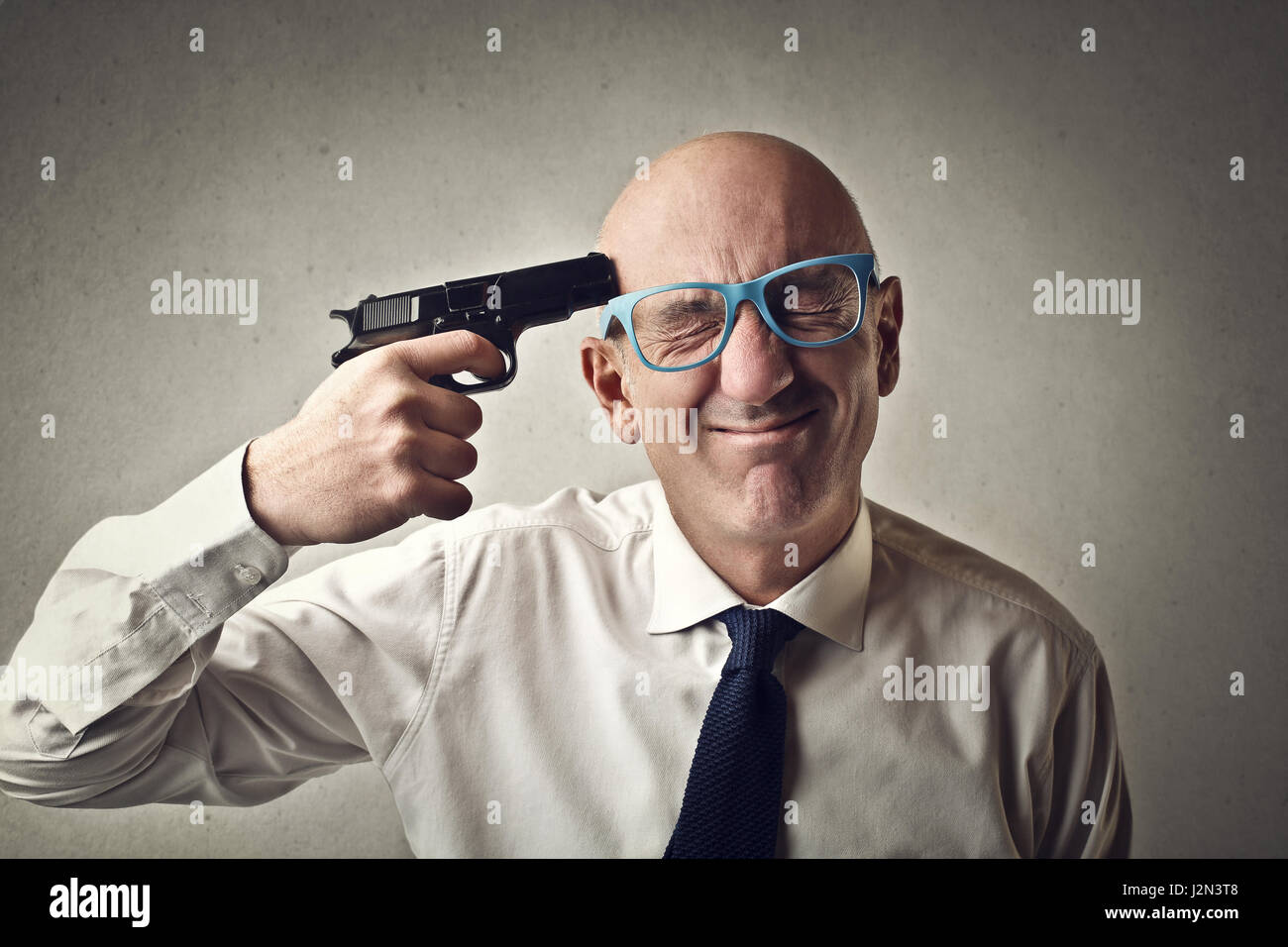 Businessman holding gun to his head Stock Photo