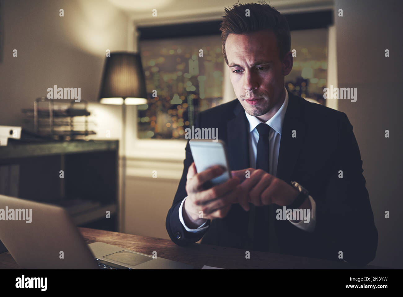 The professional lawyer sitting and using his phone in the evening