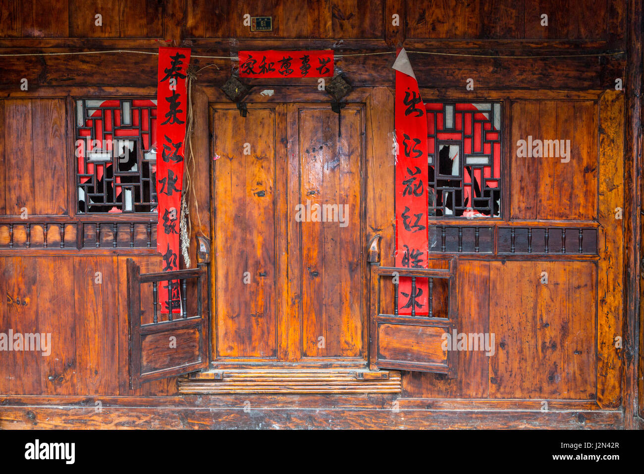 Matang, a Gejia Village in Guizhou, China.  Doorway to Private Home with Spring Festival (New Year) Scrolls Quoting Poetry by Bai Juyi. Stock Photo