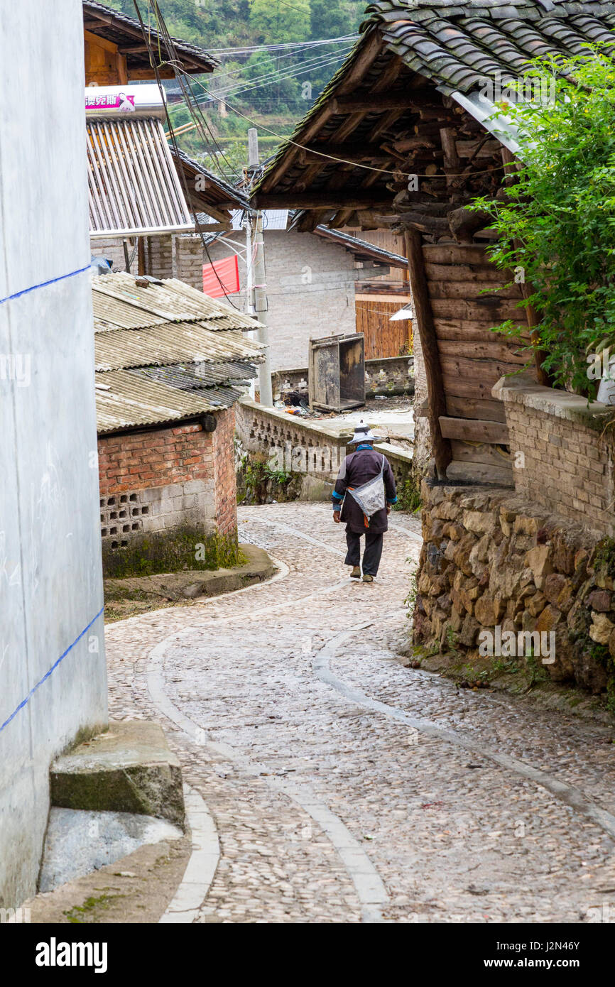 Matang, a Gejia Village in Guizhou, China.  Woman Descending Village Street. Stock Photo
