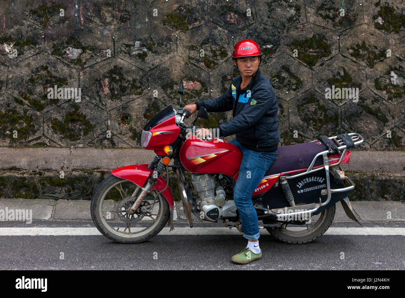 Matang, a Gejia Village in Guizhou, China.  Young Man on his Motorcycle. Stock Photo