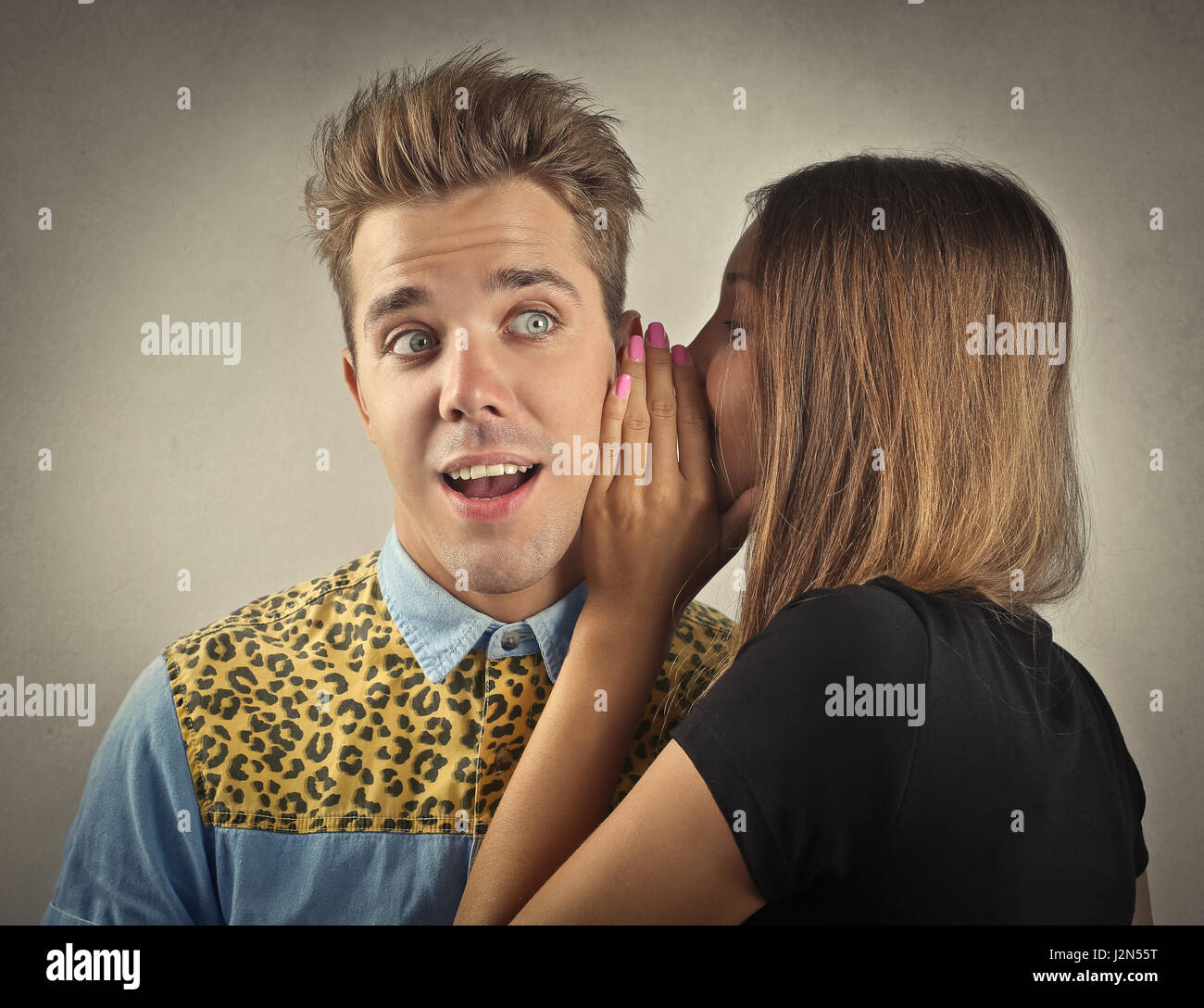 Woman whispering to young man Stock Photo Alamy