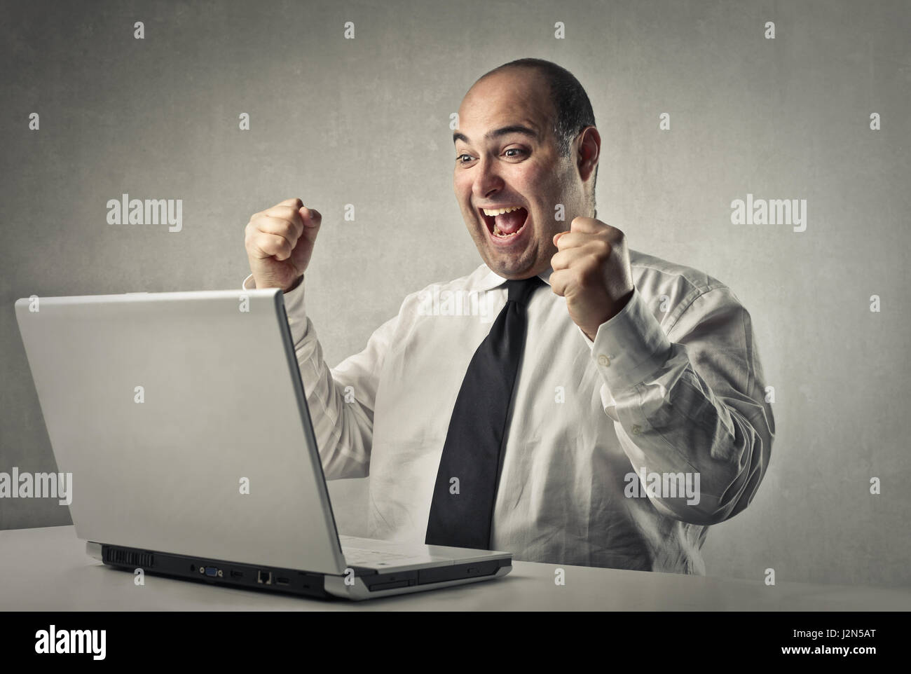Happy businessman in front of laptop Stock Photo