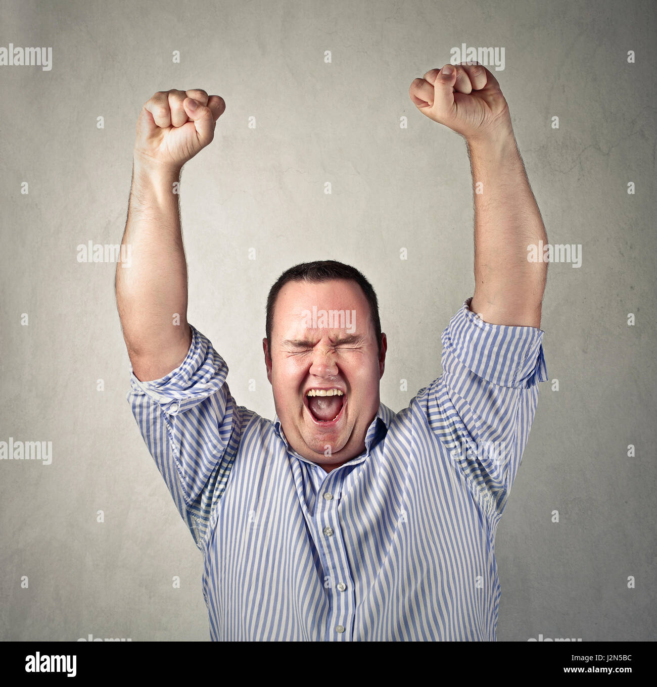 Obese man cheering inside Stock Photo