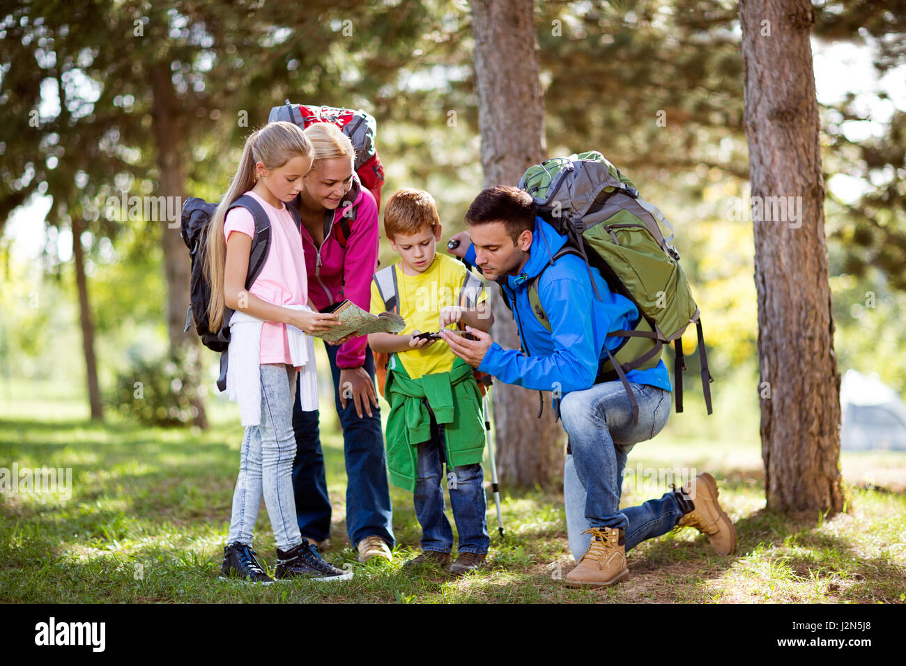 parents and child hiking in forest Stock Photo - Alamy
