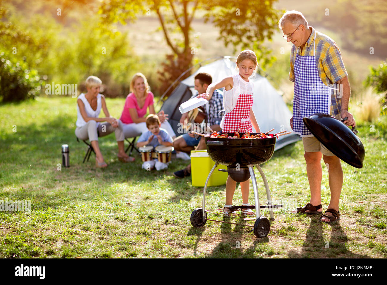 family grilling barbecue on camping Stock Photo - Alamy