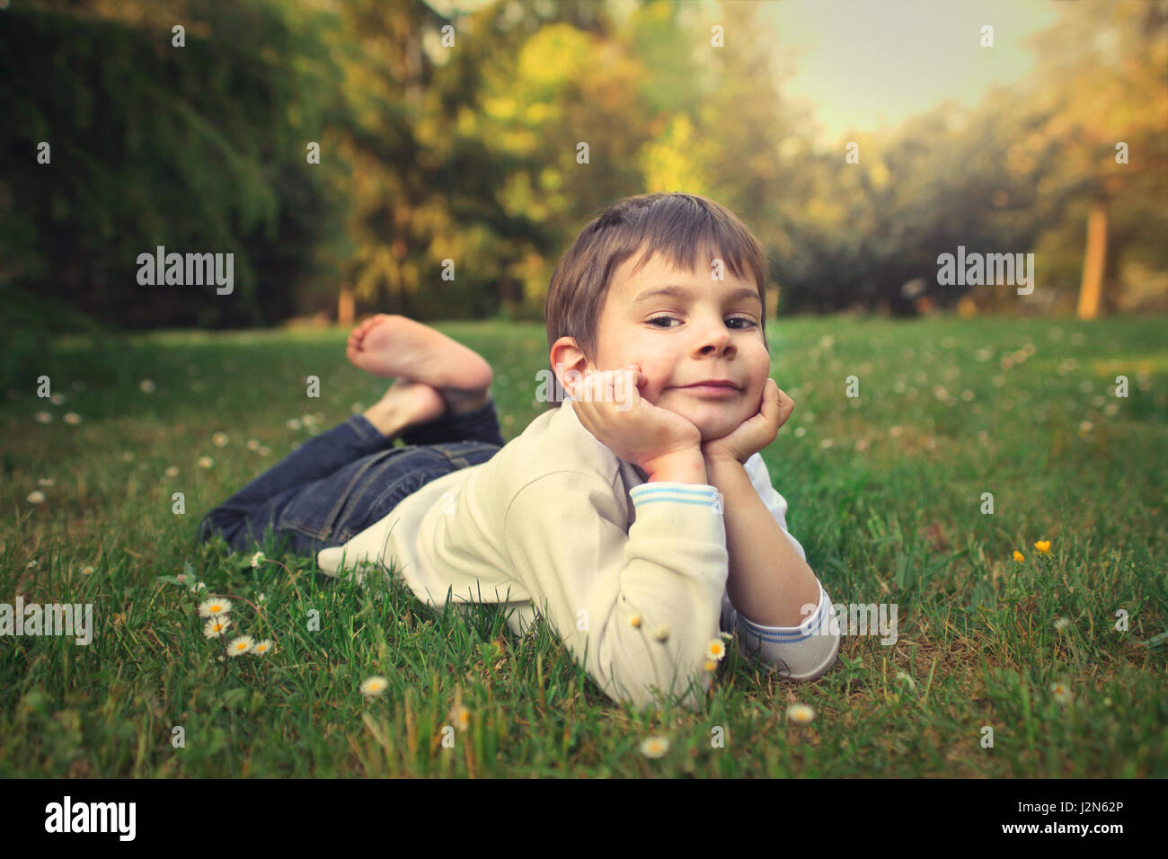 Little boy laying on the grass Stock Photo
