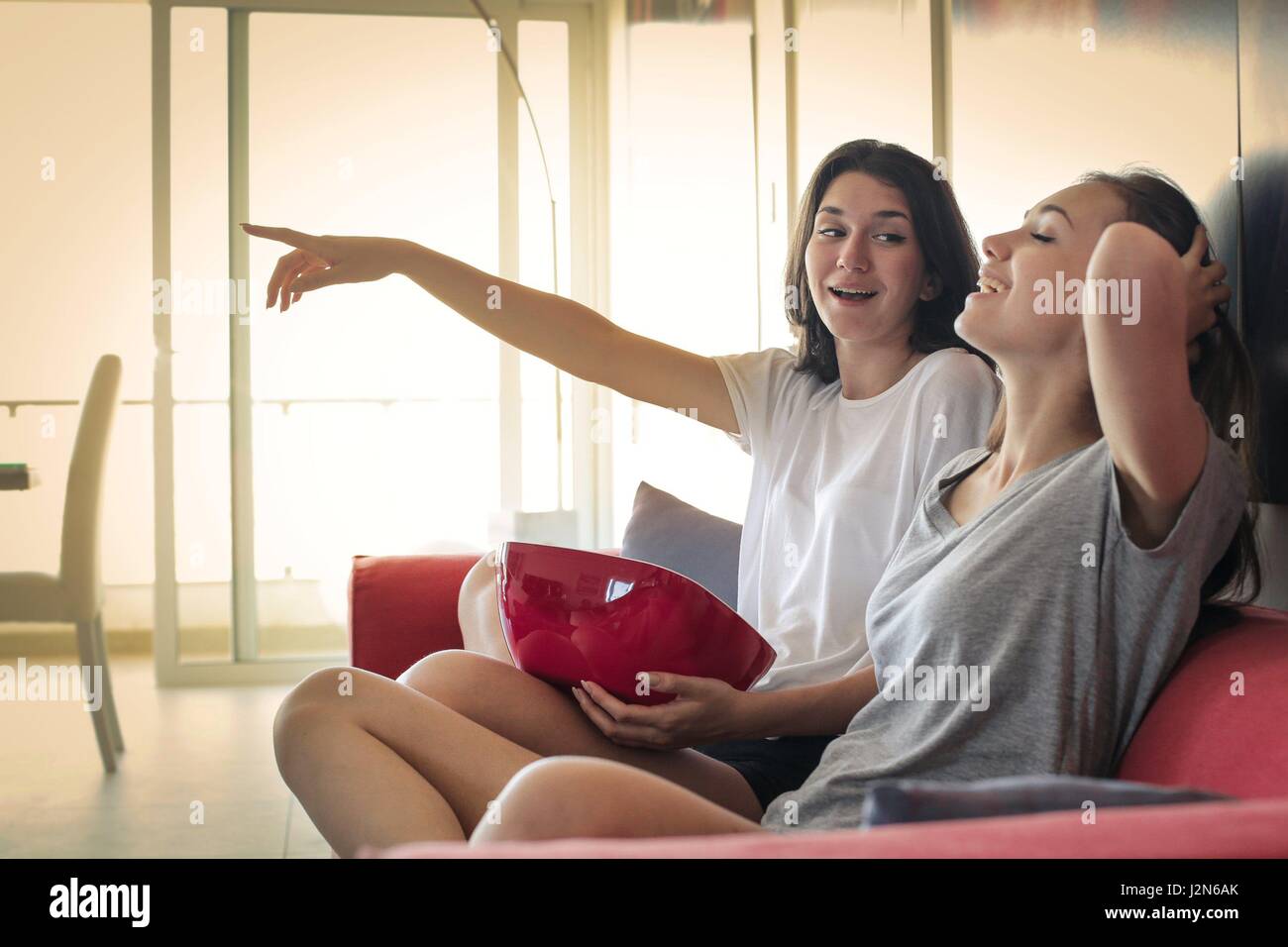 2 women friends watching TV together Stock Photo