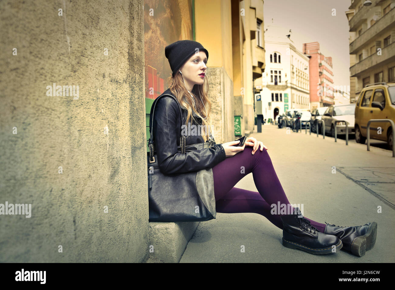 Grunge woman sitting outside Stock Photo