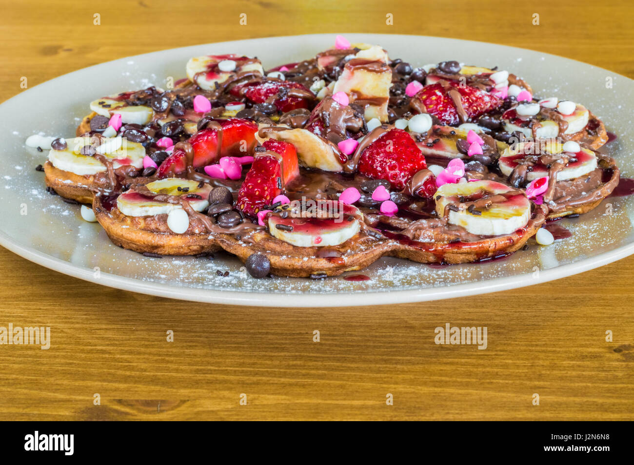 Closeup of Belgian waffles with mixed fruit and with chocolate and strawberry sauce Stock Photo