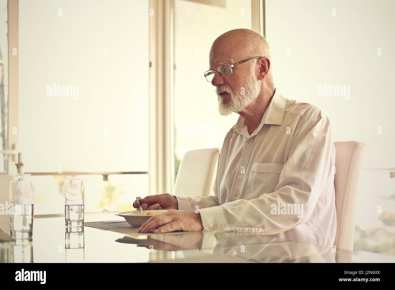 Old man eating in restaurant Stock Photo