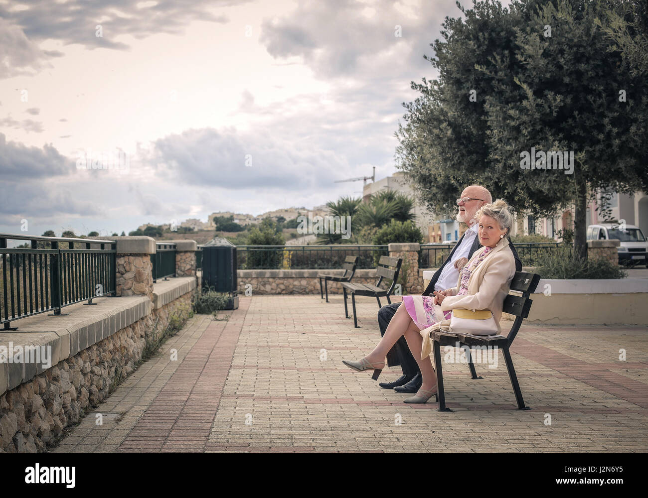 Old couple sitting on bench together Stock Photo - Alamy