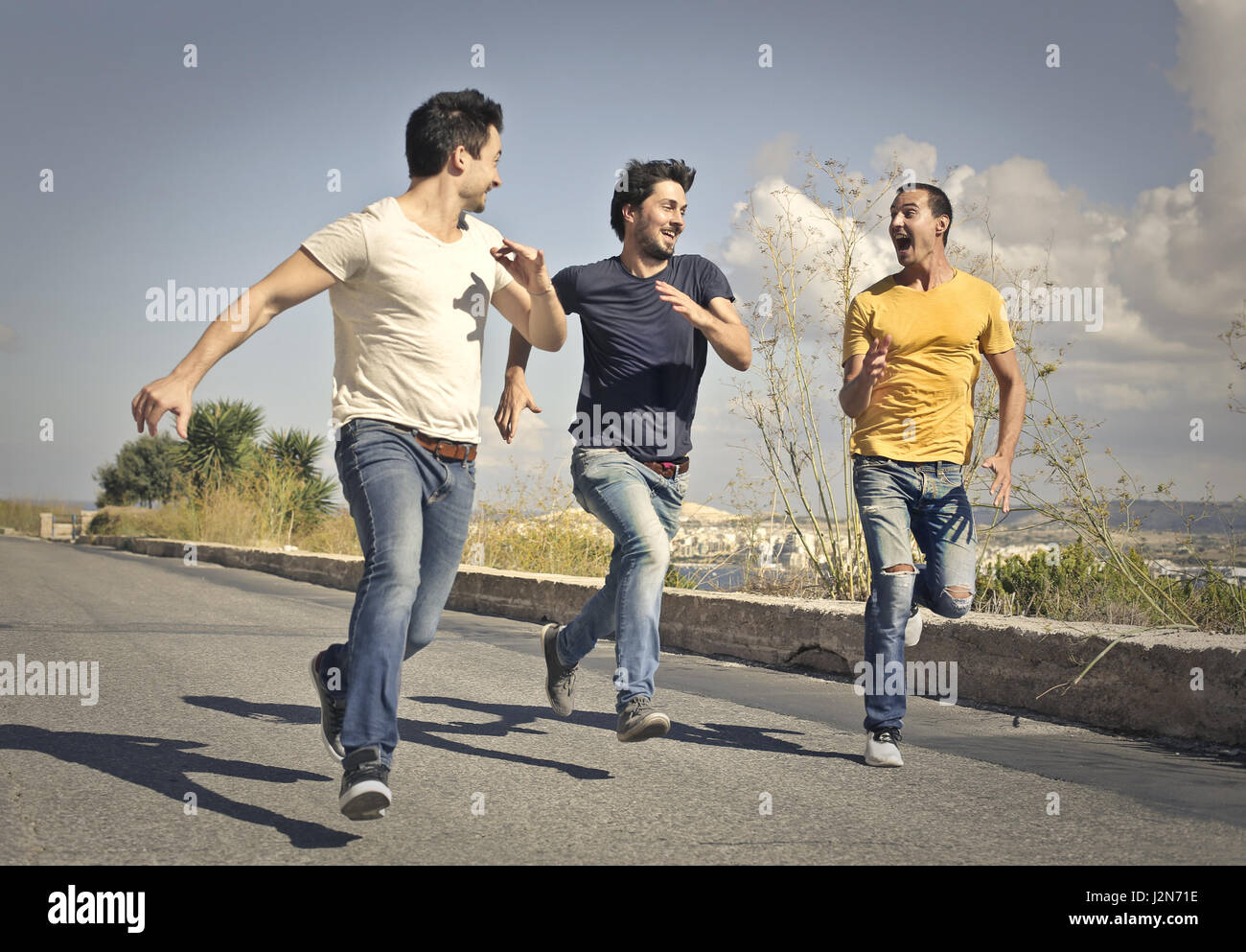 3 men running on street Stock Photo