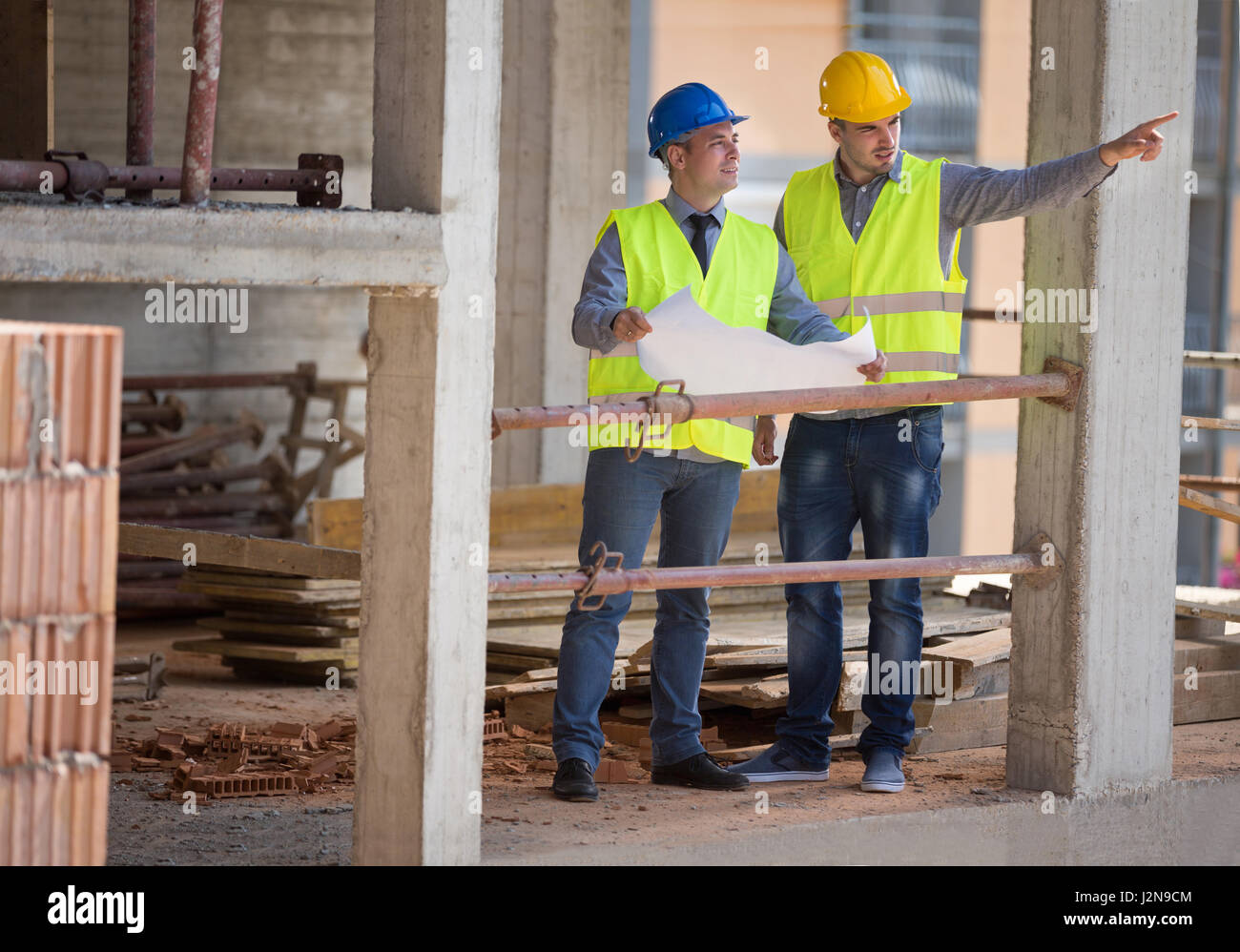 Two male architects show building place and discus with colleague ...